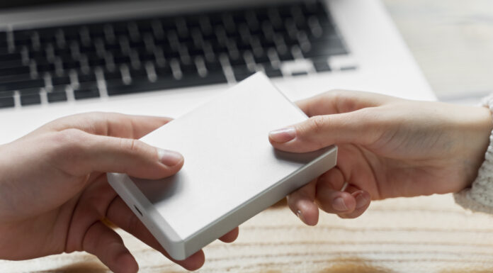 Digitalt arv: En komplett guide till att planera ditt eftermäle online En hand som lämnar över det digitala arveti form av en hårddisk